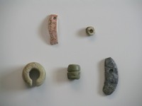 写真1時06分号住居跡出土の貝製装飾品（左）と臼玉（右）